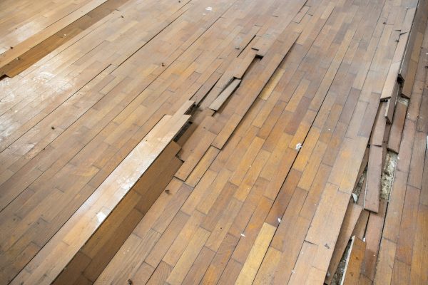 Damaged wooden floor. Floor ruined by humidity and wear. Ruined parquet.