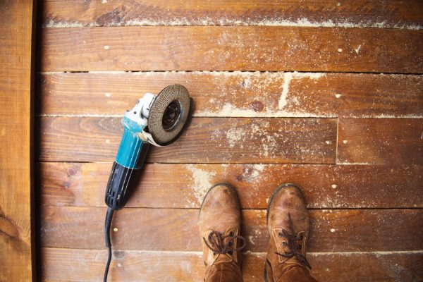 electric-grinder-machine-left-on-dusty-wooden-floo-2025-10-10-23-00-50-utc