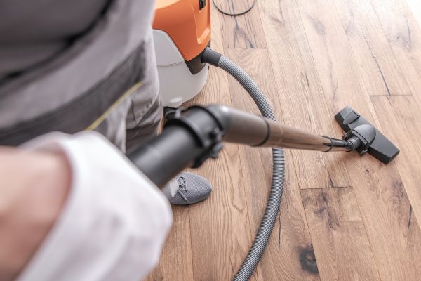 male-worker-vacuuming-hardwood-flooring-.jpg